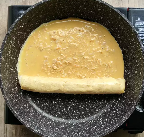 燕麦虾皮厚蛋烧,然后再倒入另一半蛋液,同样待到略微凝固后,继续卷起来。