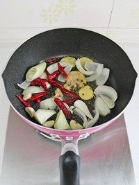 大盘鸡,锅里加油，放入<a style='color:red;display:inline-block;' href='/shicai/ 86474'>干辣椒</a>、洋葱、大葱、蒜、<a style='color:red;display:inline-block;' href='/shicai/ 37'>姜</a>、绿麻椒粒和大块鸡油，中小火煸炒至鸡油完全吐油、表面微焦。将鸡油渣拣出不用，再继续将锅里的调味料炒香。