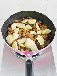 大盘鸡,放入土豆块并加盐调味,继续炖煮15-20分钟左右至土豆软糯成熟。