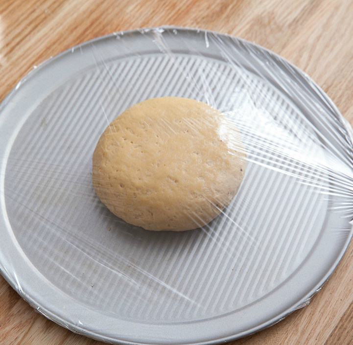 松软巧克力司康,倒在桌上,搓压成团。用保鲜膜覆盖,室温醒发1小时