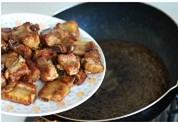 糖醋排骨,平底锅里倒入糖醋汁和少许的排骨汤,然后将煎好的肋排倒进去。