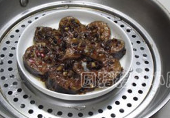 豉汁蒸鲶鱼,蒸锅内烧开水,摆上鱼盘,加盖大火蒸12分钟。