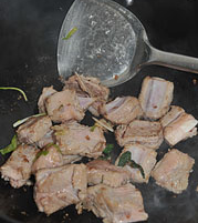 蒜蓉辣酱烧排骨,锅中放油烧热,爆香葱姜,倒入排骨反复翻炒至排骨变色,边缘稍有焦黄。