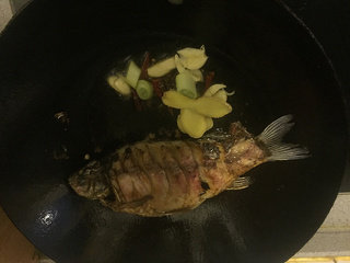 红烧鲫鱼,红烧鲫鱼的做法步骤:7 7两面都炸焦黄后,到出多余的油,放入花椒大料,红辣椒,葱姜蒜,超出香味。