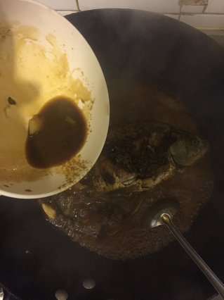 红烧鲫鱼,待锅中水剩一半的时候倒入碗汁继续小火炖十分钟,给鱼翻个身,以便更入味。