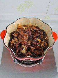 小鸡炖蘑菇,将榛蘑铺在鸡块上面,再将浸泡榛蘑的水倒入锅中,加盐调味。