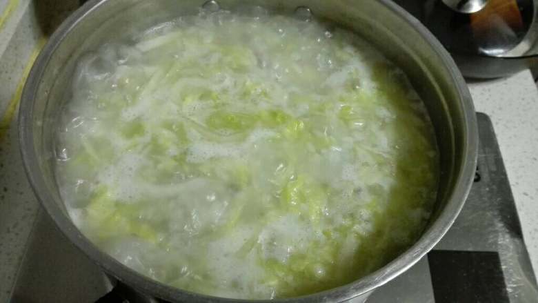 羊肉白菜咸饭,将炒好的白菜肉馅一起倒入煮米的锅中,小火慢慢熬。