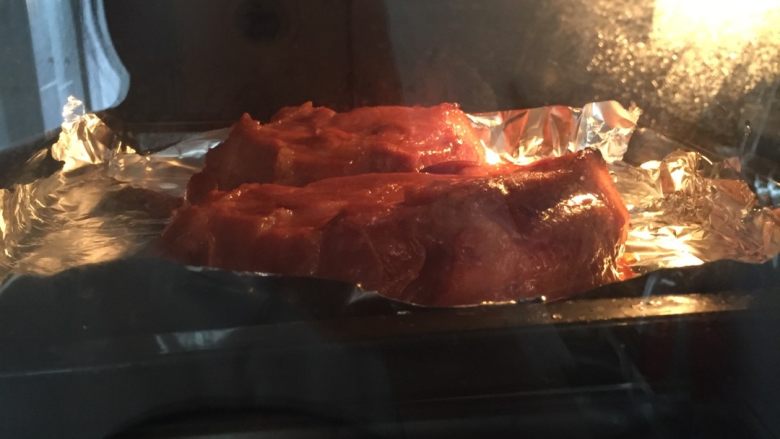 自制叉烧烤肉,如图烤箱180预热5分钟,烤盘铺两层锡纸,把肉放在烤盘里。上下火200度中层30分钟,期间翻一次面