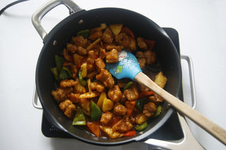 菠萝咕噜肉,倒入菠萝片、青红彩椒,翻拌均匀后关火,再倒入炸好的肉片,快速翻匀,让每块肉片都裹上糖醋汁,美味的咕噜肉就可以出锅了。