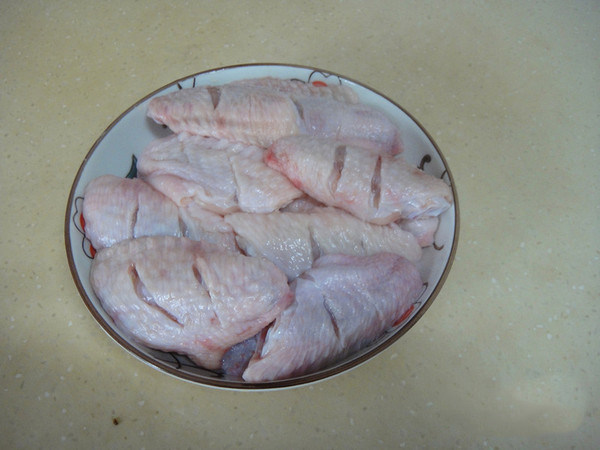 上海糟油脱骨鸡翅,解冻后浸入清水里一小时后洗净捞起,用刀把每个鸡翅各斜切2刀