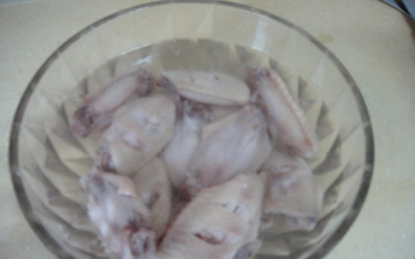 上海糟油脱骨鸡翅,煮熟的鸡翅捞起加入事先准备的冰水里,抓洗一下捞起沥干水分