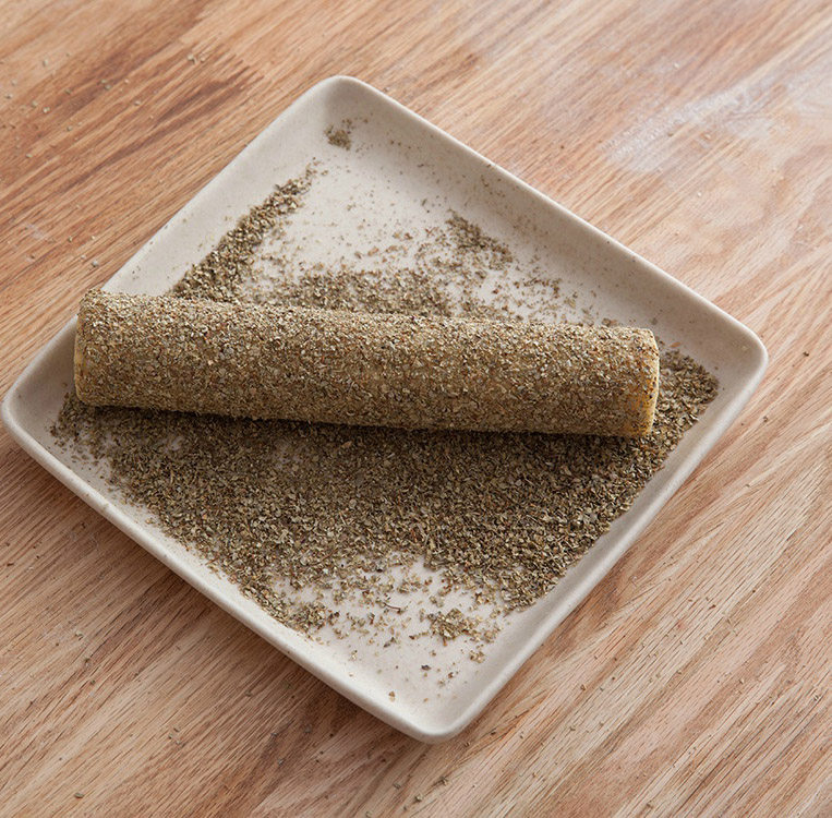 明星款零食-法式切达芝士咸饼干,取出面团移除外包装,在盘內放入香葱粉,将面团涂抺<a style='color:red;display:inline-block;' href='/shicai/ 1118'>蛋液</a>后放置于香葱粉內翻滚,使其表面均匀裹上一层葱粉。