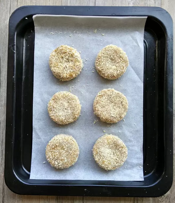 土豆可乐饼(健康版),烤盘铺上烤箱纸,放上土豆饼。