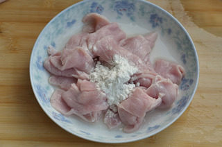 黄瓜汆里脊肉片,捞出里脊肉片,洒上淀粉,抓匀。