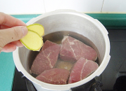 自制咖喱牛肉干,把牛肉放入高压锅内,加入适量的水、姜片。