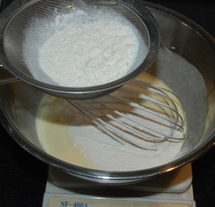 柠檬味奶油蛋糕,筛入80克面粉和3克泡打粉拌匀,加入料理机打过的面粉柠檬皮拌匀。
