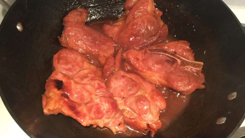 叉烧肉(无烤箱版),将腌制好的肉放入锅中,大火沸腾后转中大火,慢慢收汁,偶尔翻面一下,汁快收干的时候要用筷子经常移动一下位置防止烧焦,待汁完全收干并且肉的两面都微焦金黄色即可起锅