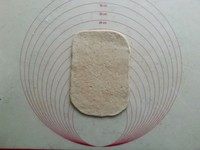杂粮乳酪米豆包,擀成长方形,翻面。