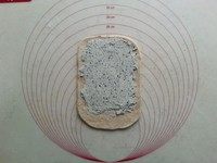 杂粮乳酪米豆包,将乳酪馅均匀抹在面片上,留出两边和尾端收口。