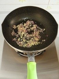 鸡汤菌菇焖饭,锅里倒适量的油烧热,放入洋葱末和蒜末,中火炒至洋葱变透明。