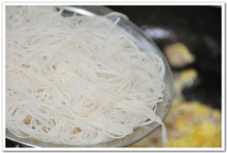 什锦炒粉,蛋液凝固后，将泡好的粉丝下锅。