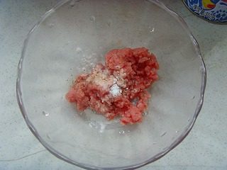 西湖牛肉羹,肉糜放入碗中,调入少许盐、白胡椒粉、水淀粉搅匀,淋上薄油腌制20分钟。