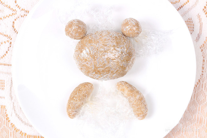 小熊礼物便当,配菜准备好的时候米饭刚好蒸好,翻松晾凉,用保鲜膜包裹捏成大小不一的饭团,一个大圆做小熊头,两个小圆做耳朵,两个长条做手臂