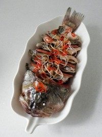 麒麟鲈鱼,在鱼上放上葱丝和红椒丝,淋上<a style='color:red;display:inline-block;' href='/shicai/ 864'>蒸鱼豉油</a>和适量的盐。
