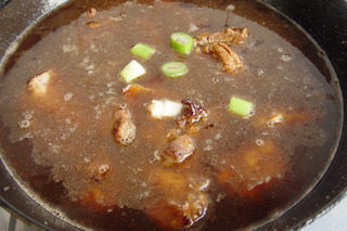 白萝卜烧排骨,中小火翻炒五分钟,待排骨内的油稍出,注入半锅热水(漫过排骨),大火烧开,再放入葱段,盖上锅盖,小火焖烧一小时。