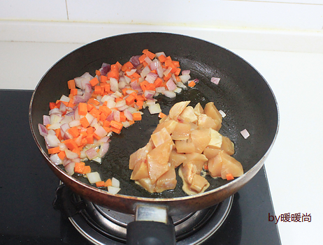 咖喱鸡肉炊饭,将洋葱和胡萝卜拨到一边,下鸡胸肉翻炒至变色。