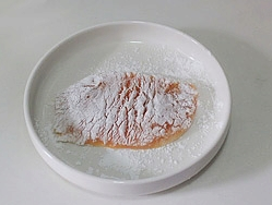 日式香酥鸡排饭,将腌制好的鸡胸肉在淀粉里面打个滚,然后抖掉表面多余的淀粉。