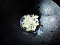 韭菜花炒茄子,锅里放油,放入葱、姜、蒜炒出香味。
