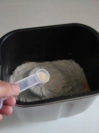 酒渍提子面包,在面粉的顶部用手指挖出一个浅坑,放入酵母后再用面粉把酵母盖上。