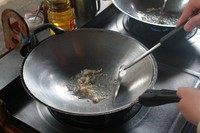 泰式炒面,锅中入油,烧至六成热,下蒜头煸炒。