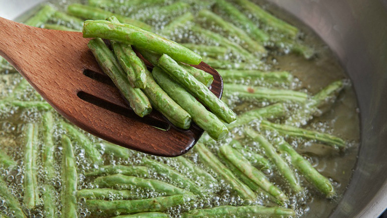 干煸四季豆,炸至表皮有泡泡，捞出沥干