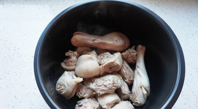 薏米莲子老鸭汤,煮好的鸭块捞出冲去血沫,放进电饭煲