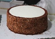 象棋可可奶油生日蛋糕,再沾上蛋糕屑,把掉在底部纸垫上的去除,再挤上一圈围边。