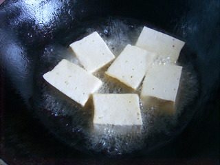 豆腐箱子,锅中多倒些油，八成热时将豆腐炸一下，炸至六面金黄捞出。