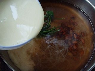 甜沫,稍煮后捞出料盒,再放菠菜、粉条、红豆、花生米,水沸后立即倒入小米糊,边倒边搅。