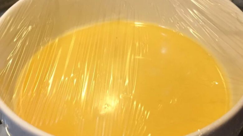 宝宝辅食果香牛奶鸡蛋羹,如图过滤好的蛋液倒入容器中,盖上保鲜膜,用牙签扎洞帮助透气,上锅蒸15-20分钟,中间不要掀盖子
