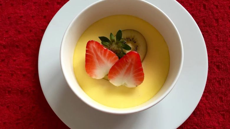 宝宝辅食果香牛奶鸡蛋羹,如图放入草莓,草莓叶子洗净装饰,美味的水果鸡蛋羹快来品尝吧。