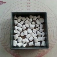 巧克力棉花糖切方,将一半量的大粒棉花糖,每粒剪成4份,均匀码在面皮上面,包括两个小塔和一个方模