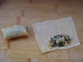 炸菠菜脯,将菠菜馅分别放在豆腐皮上,卷起来。