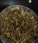 龙井茶香虾,炸到茶叶发脆,捞出沥油备用。