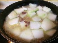 干贝火腿烧冬瓜,加入冬瓜,加没过冬瓜的热水,把泡干贝的水也加进去,盖锅盖中小火烧,直到冬瓜片变软,如果水烧干可适量添加热水。