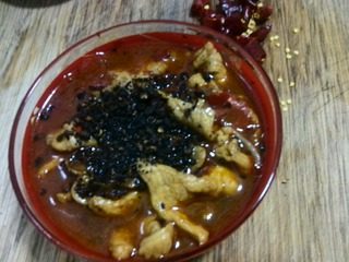 麻辣水煮肉片,锅洗干净,大火烧热后再放入适量干花椒,小火将花椒炒至焦香,用锅铲碾碎后撒在肉片上。
