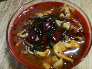 麻辣水煮肉片,锅中入适量油,入干辣椒炸出香味后将辣椒撒在肉片上,再洒上适量辣椒面。