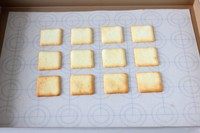白色恋人饼干,13.将烤盘放到烤箱中层,上火180度,下火160度烤9分钟样子,直到饼干的四边出现金黄色即可出炉,出炉后把硅胶垫从烤盘里提出来放桌上,用抹刀把饼干轻轻从硅胶垫上移除,再把硅胶垫上放瓦片酥继续同样的方法把剩下的面糊烤完