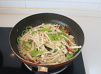 蚝油海鲜菇炒鸡丝,下海鲜菇,转中火翻炒3分钟左右,至海鲜菇变软。