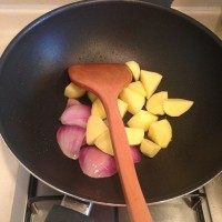 咖喱猪排饭,锅里倒入底油,油热后先下洋葱,洋葱炒出香味后再下土豆,翻炒2-3分钟